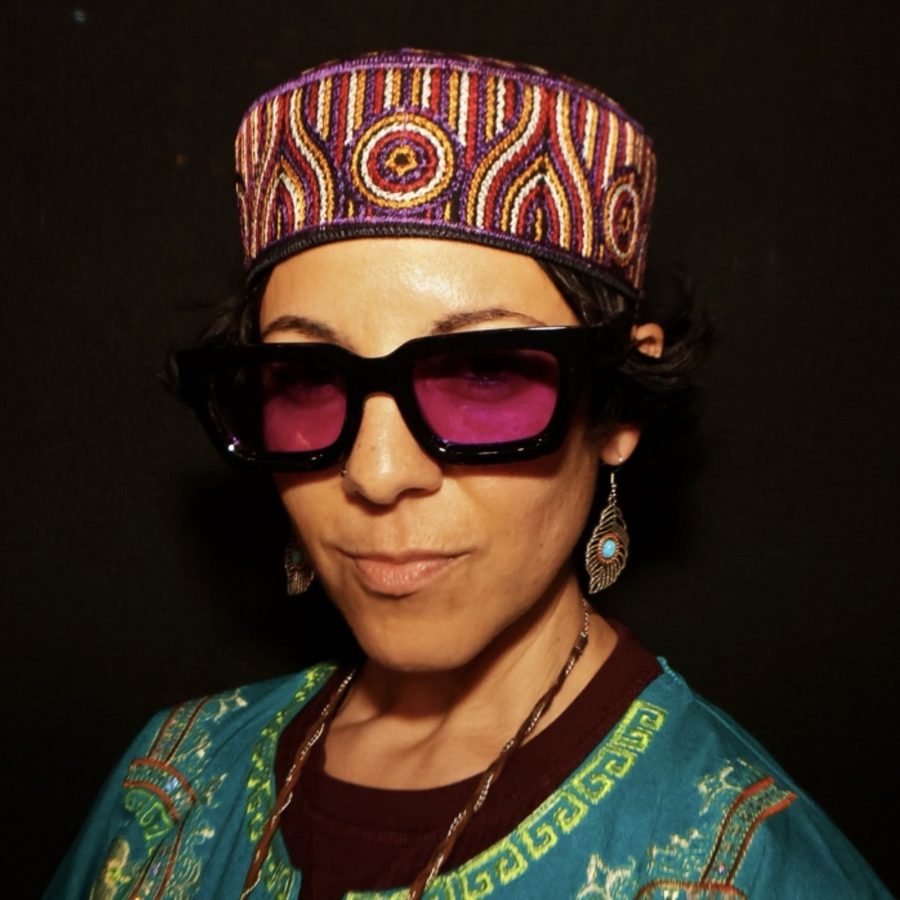 Nejma Nefertiti in purple sunglasses and an embroidered hat